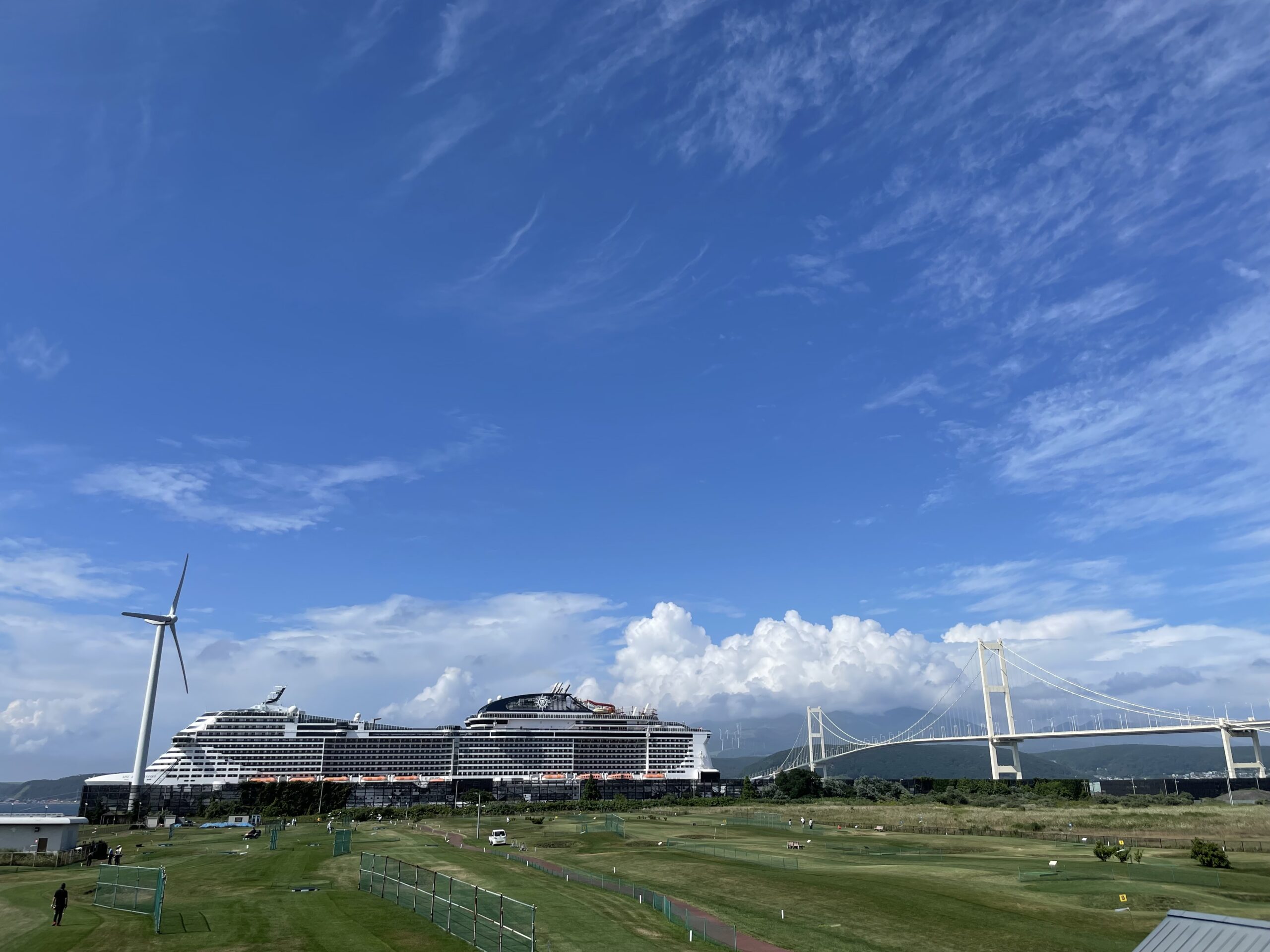 東室蘭港に停泊するMSCベリッシマと風力発電機、橋の風景